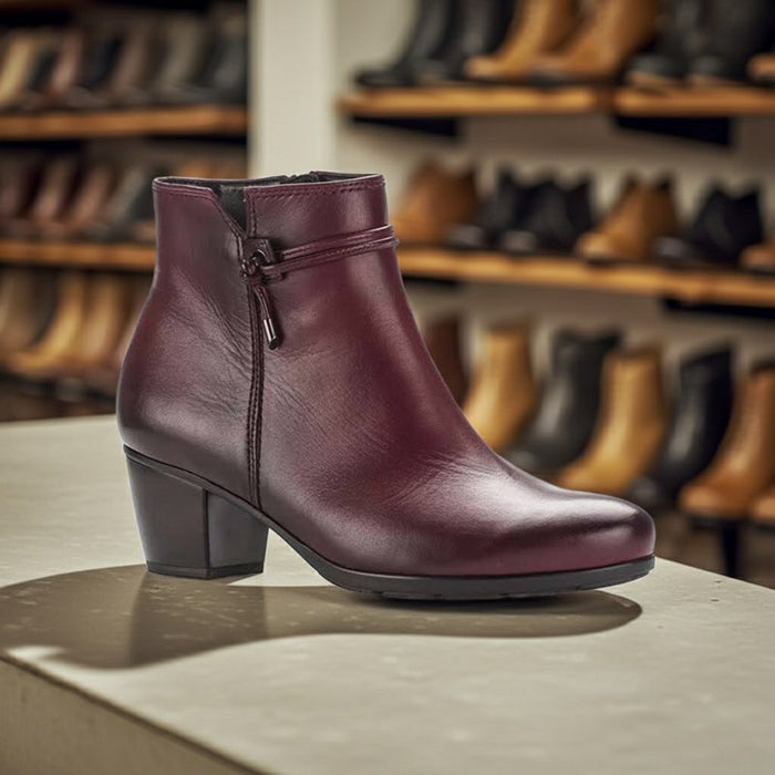 Women’s burgundy leather heeled ankle boots with side zip, strap, and square block heel