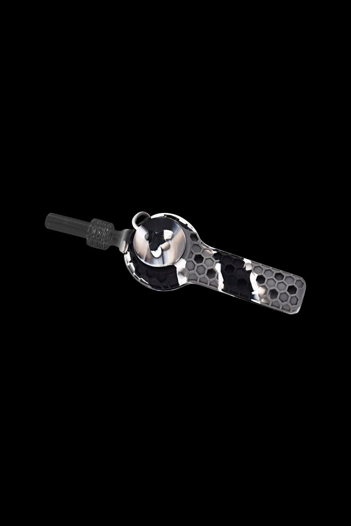 Black and white honeycomb patterned silicone dab straw with a glass tip, isolated on a black background.