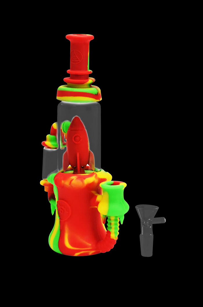 Red and green silicone water pipe with a rocket ship design, and a glass downstem beside it.